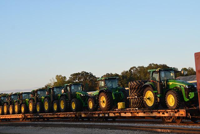 Deere tractors on rail cars waiting to be shipped out of a Deere & Co. plant in Waterloo, Iowa. Deere announced Monday it would cut another 813 workers at plants in Illinois and Iowa in the coming months. Deere had already announced more than 800 job cuts in Iowa earlier this year. (DTN file photo by Chris Clayton)